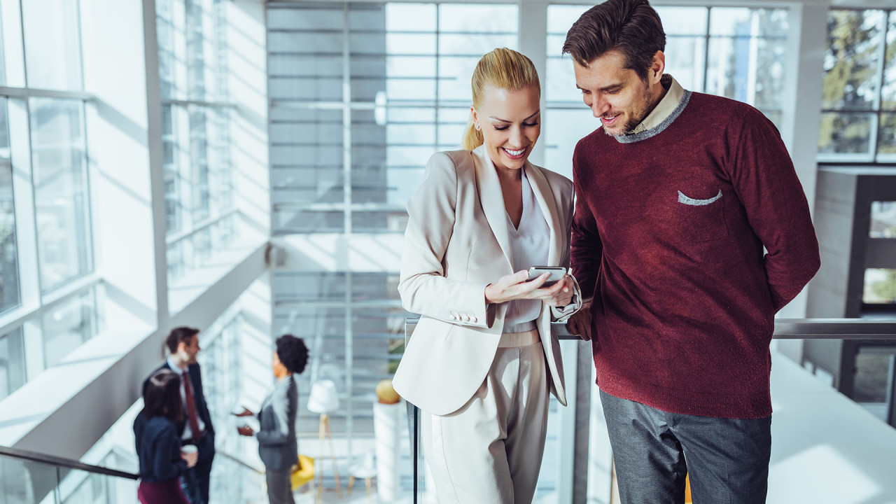 Kobieta pokazuje coś mężczyźnie na telefonie, ilustracja do artykułu o AFAIK