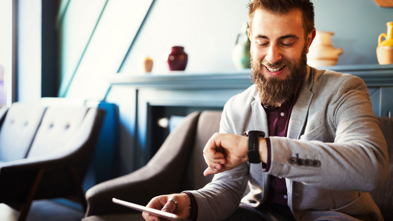 Mężczyzna sprawdzający godzinę na zegarku, ilustracja do artykułu wyjaśniającego znaczenie angielskiego akronimu TTYL