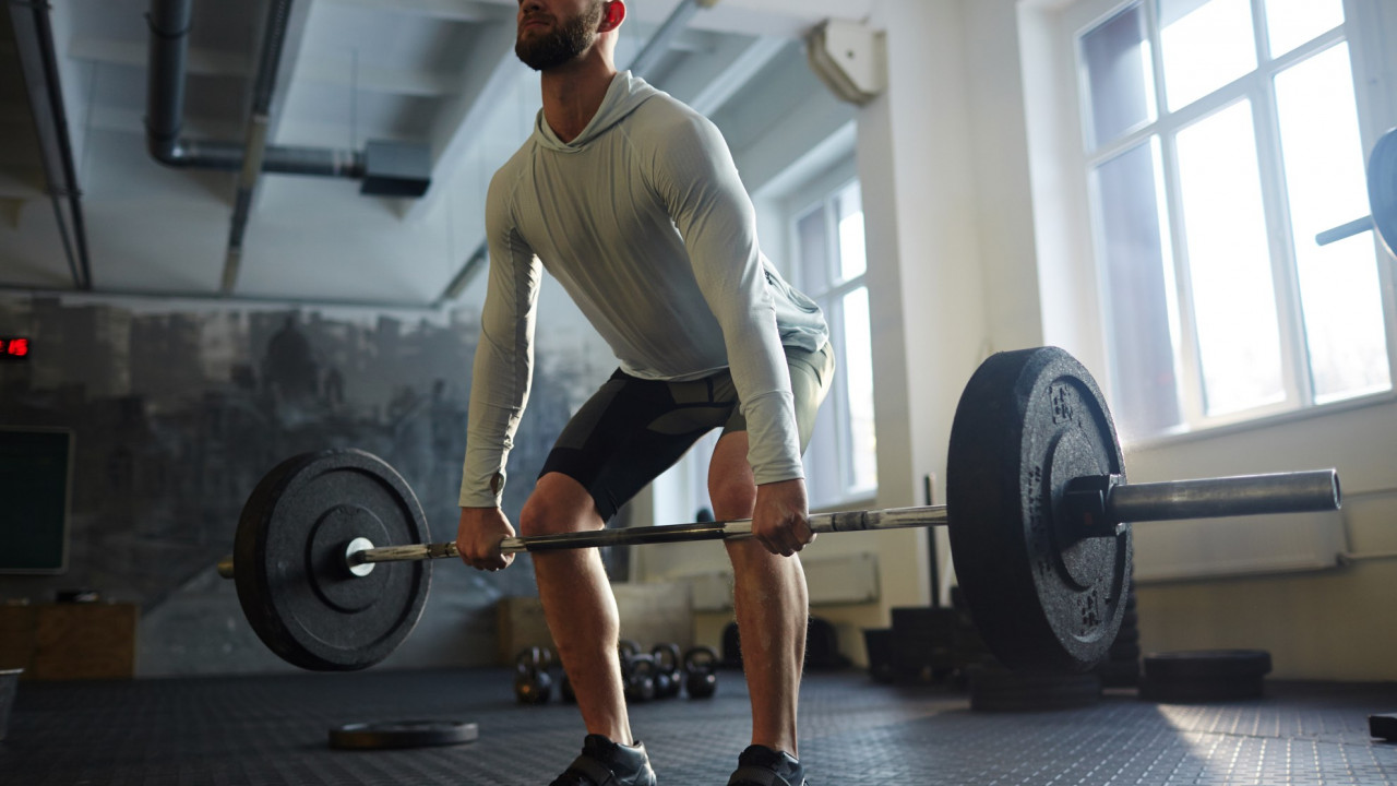 Mężczyzna wykonujący martwy ciąg, ilustracja do artykułu wyjaśniającego czym jest RM