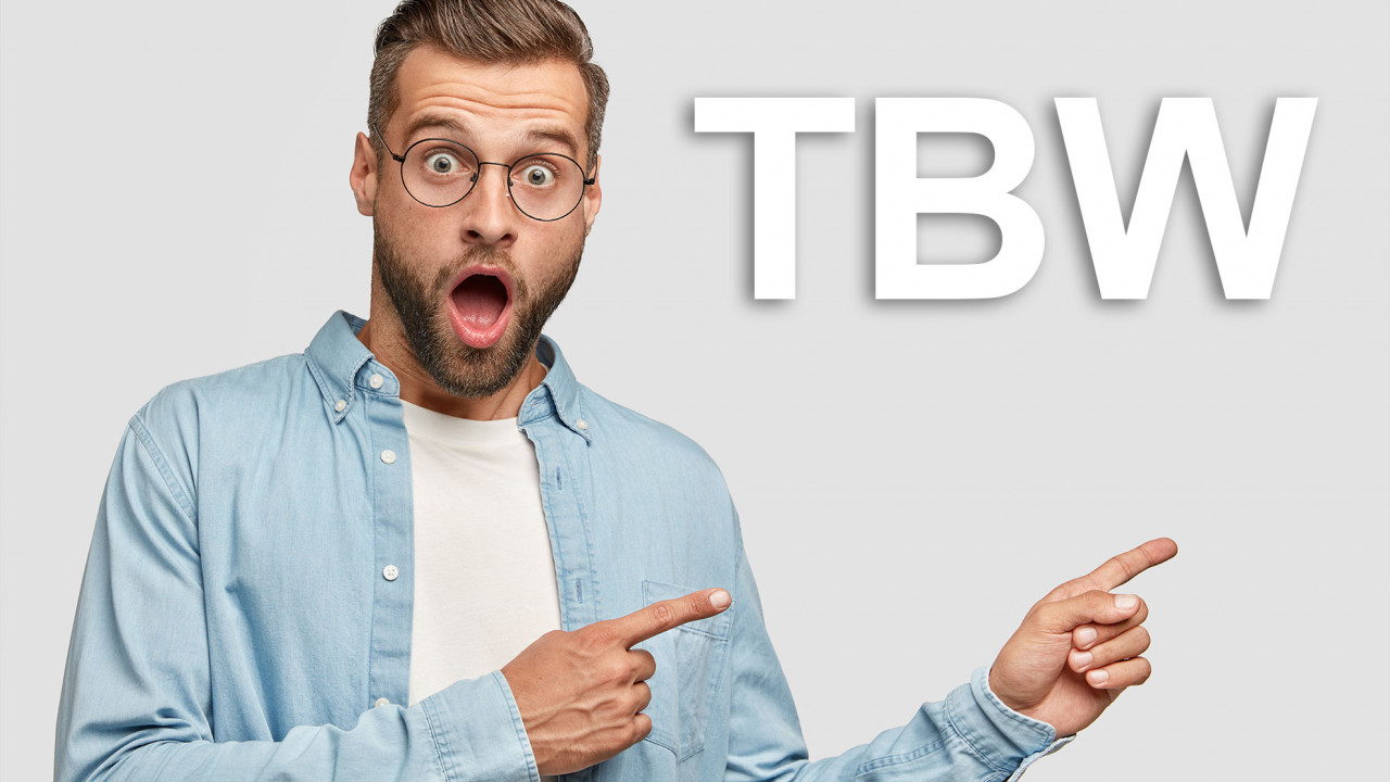 Mężczyzna wskazujący na akronim TBW