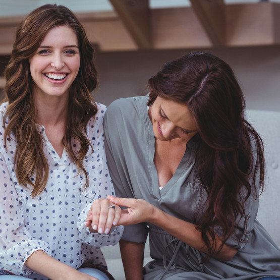 Ilustracja kobiety uwielbiane przez mężczyzn, jedna kobieta drugiej ogląda pierścionek zaręczynowy