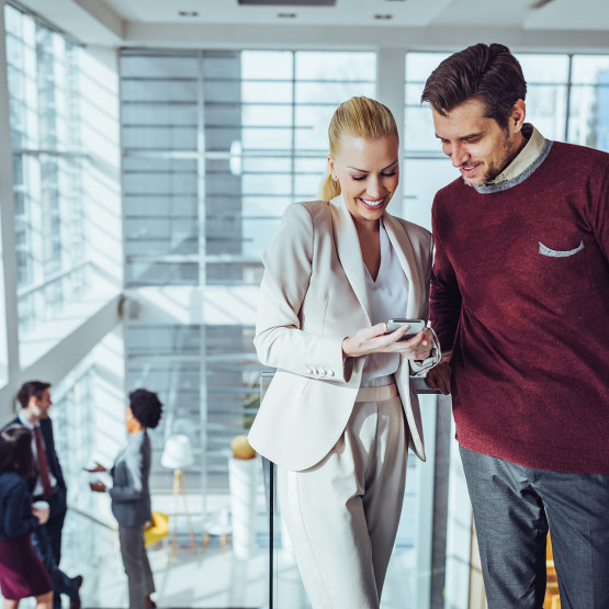 Kobieta pokazuje coś mężczyźnie na telefonie, ilustracja do artykułu o AFAIK