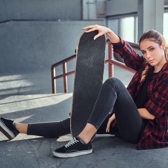 Dziewczyna prezentuję górną część deskorolki z gripem