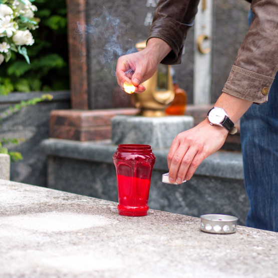 zapalanie znicza na cmentarzu, ilustracja do artykułu