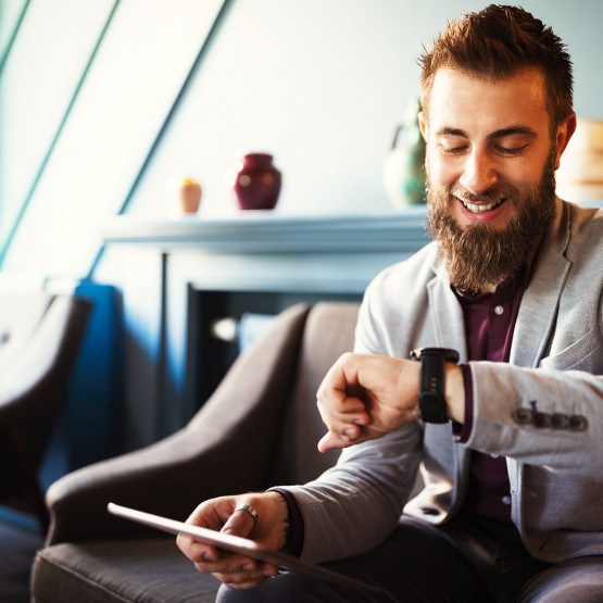 Mężczyzna sprawdzający godzinę na zegarku, ilustracja do artykułu wyjaśniającego znaczenie angielskiego akronimu TTYL