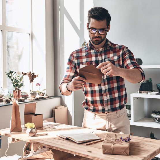 Mężczyzna otwiera kartkę z podziękowaniami, ilustracja do artykułu o podziękowaniach za obecność na imprezie urodzinowej