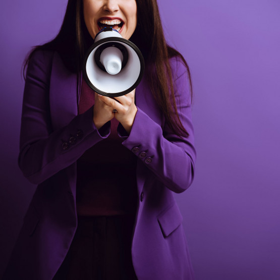 kobieta ogłaszająca informacje przez megafon, ilustracja do artykułu tłumaczącego skrótowiec TBA