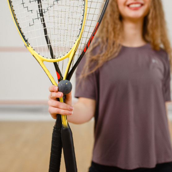 Kobieta pokazuje piłkę do squasha