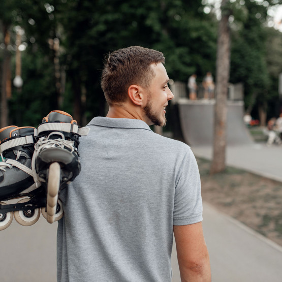 Ilustracja do artykułu o miejskich sportach, mężczyzna niosący łyżworolki