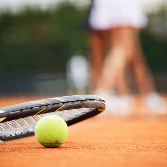 Piłka i rakieta tenisowa na korcie, ilustracja do artykułu